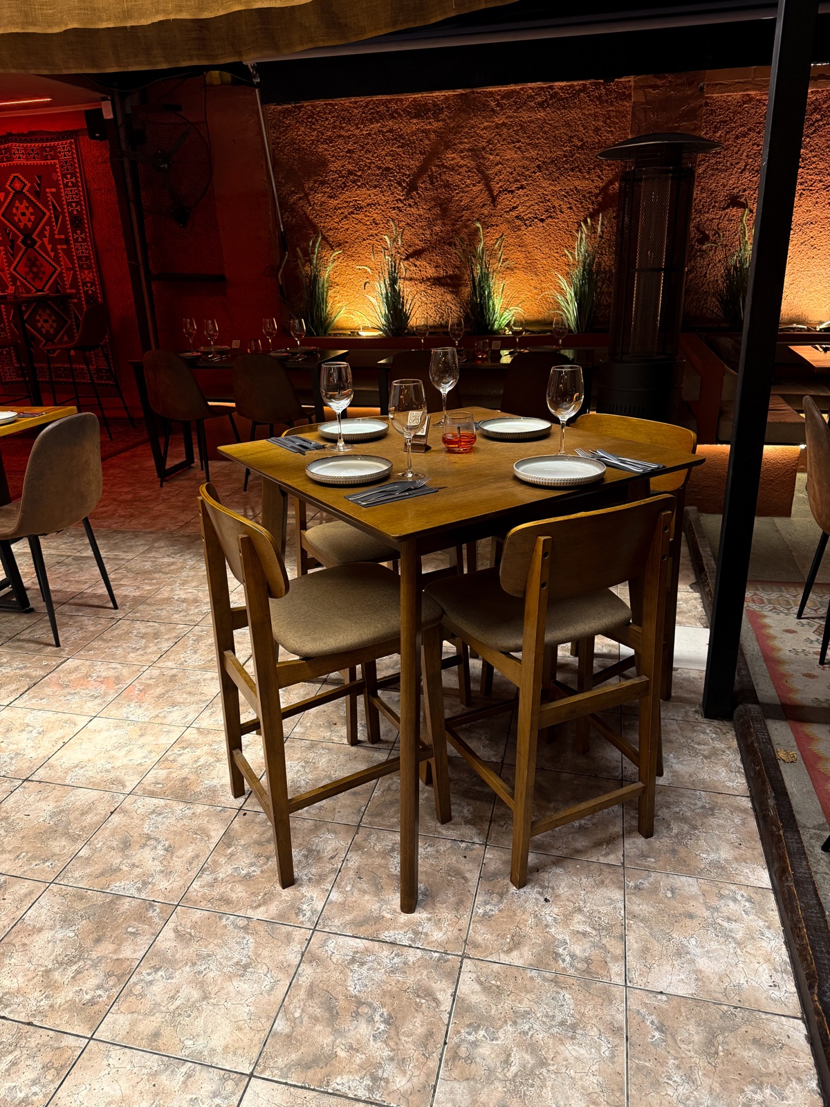 Amal: mesa de madera preparada para cuatro personas en un salón de luz cálida