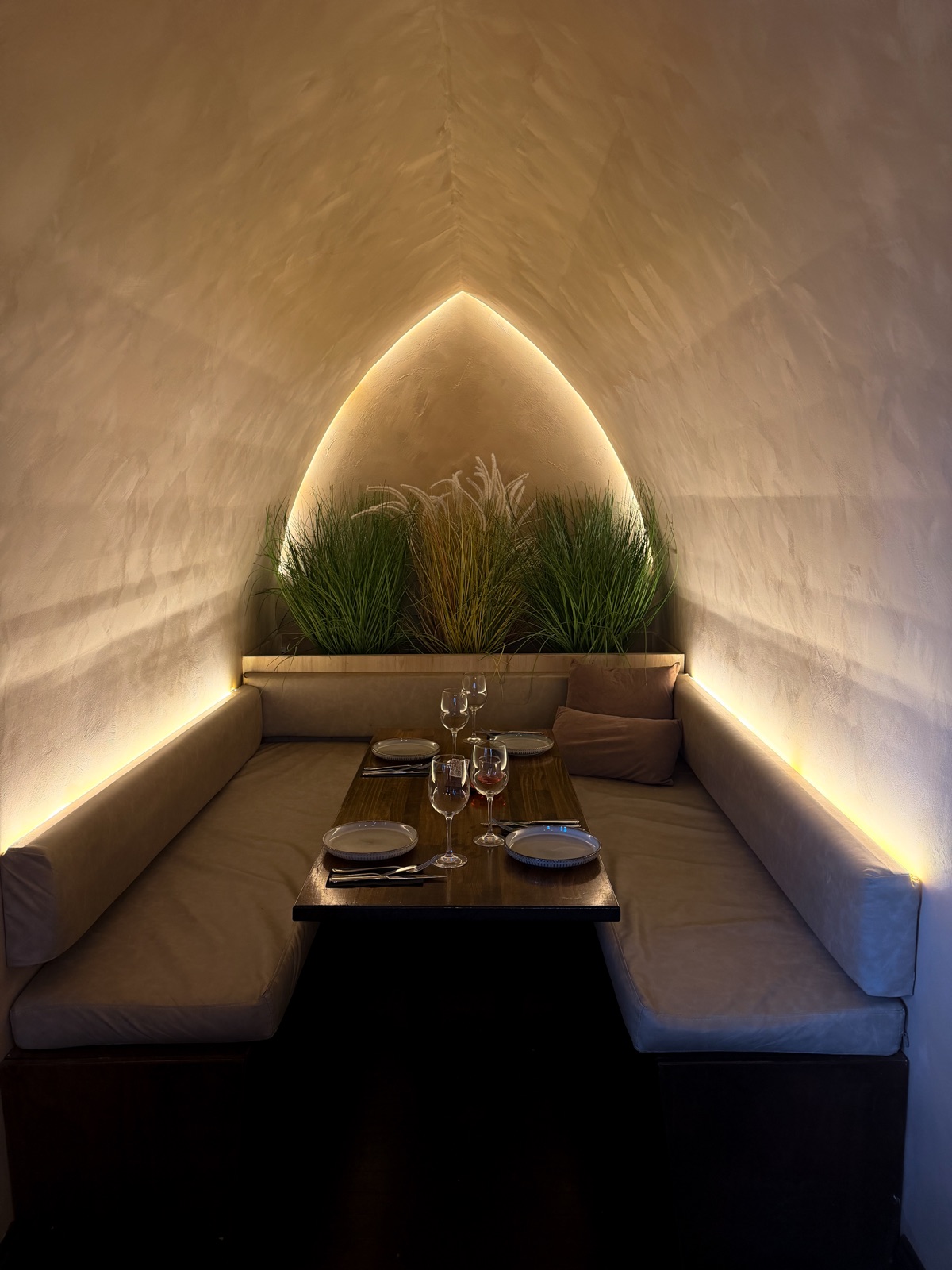 Mezquita salón: mesa preparada entre bancas bajo un nicho iluminado