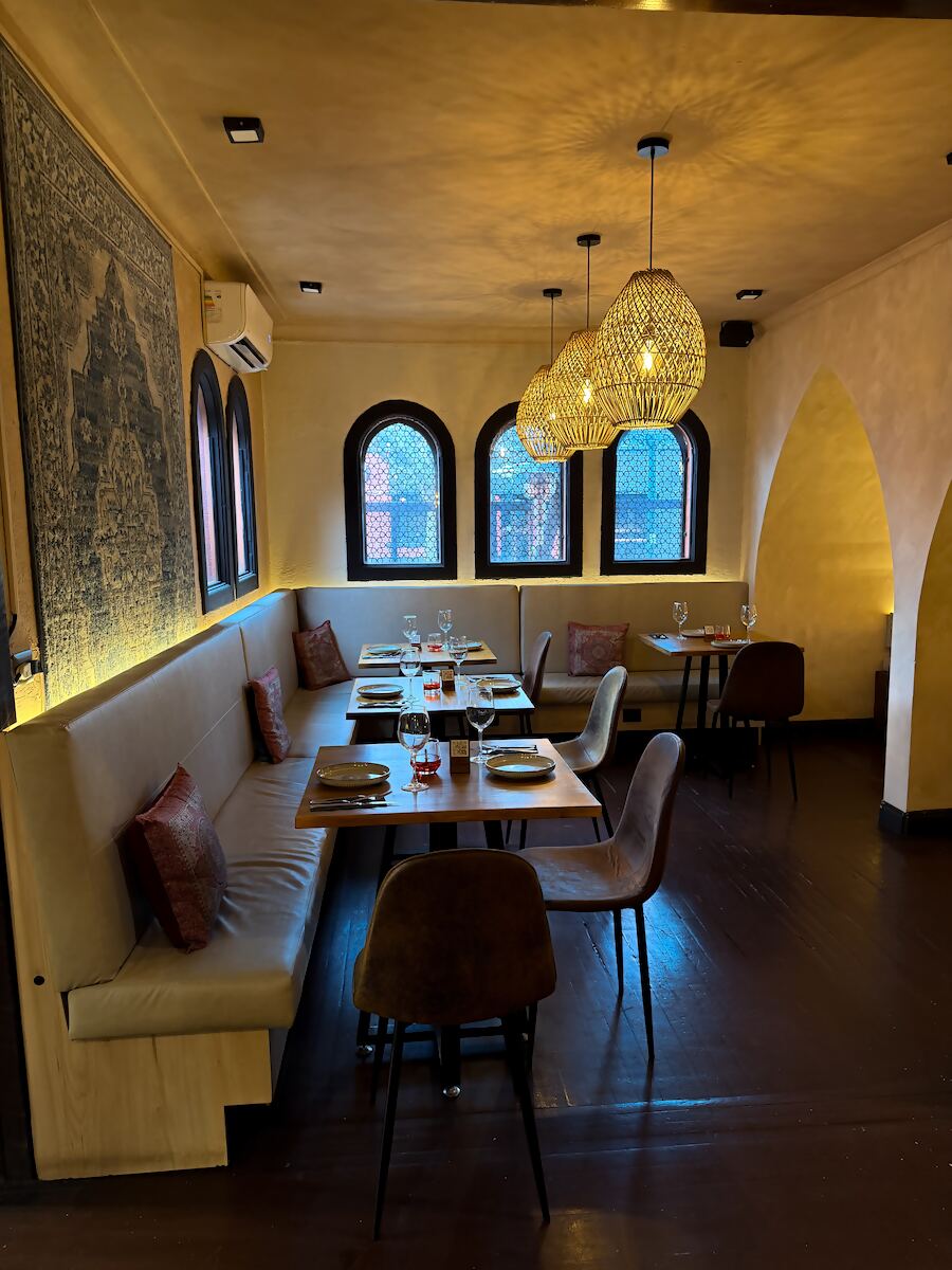 Salón principal con ventanales de arco y lámparas de mimbre