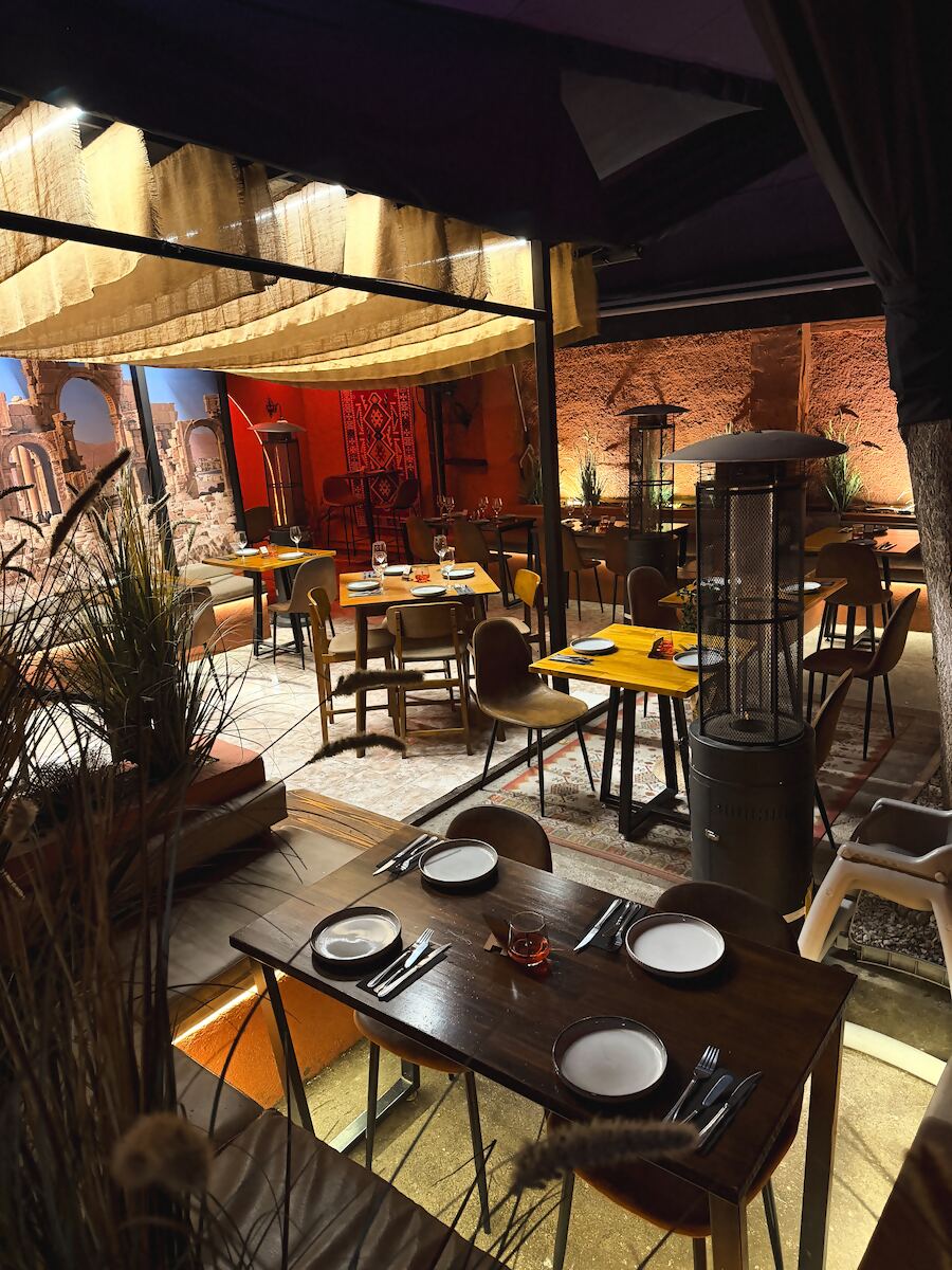Terraza interior techada con mesas y estufa